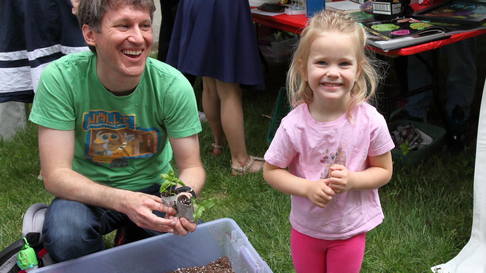 A father and daughter plant basil at WestFest 2018